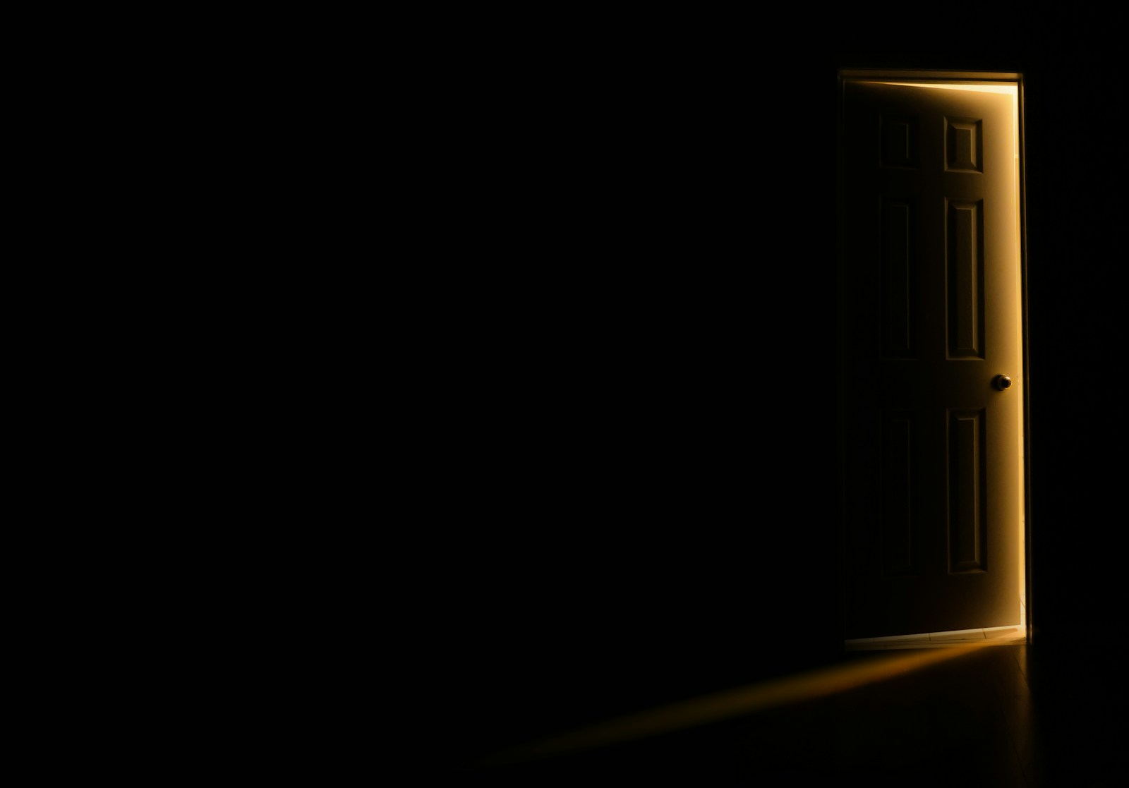 Open door letting light into a dark room