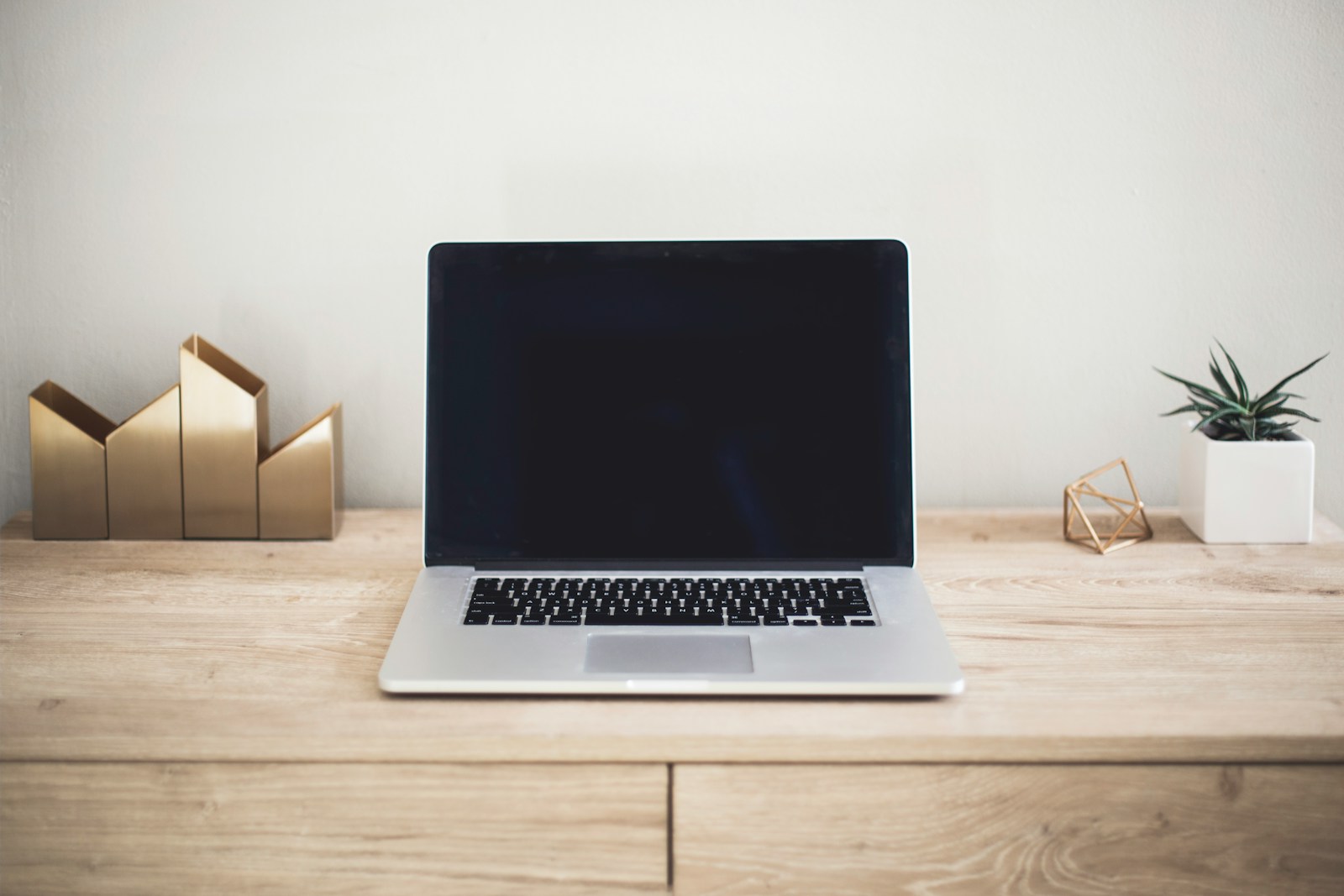 Laptop on a wooden table in a bright home office