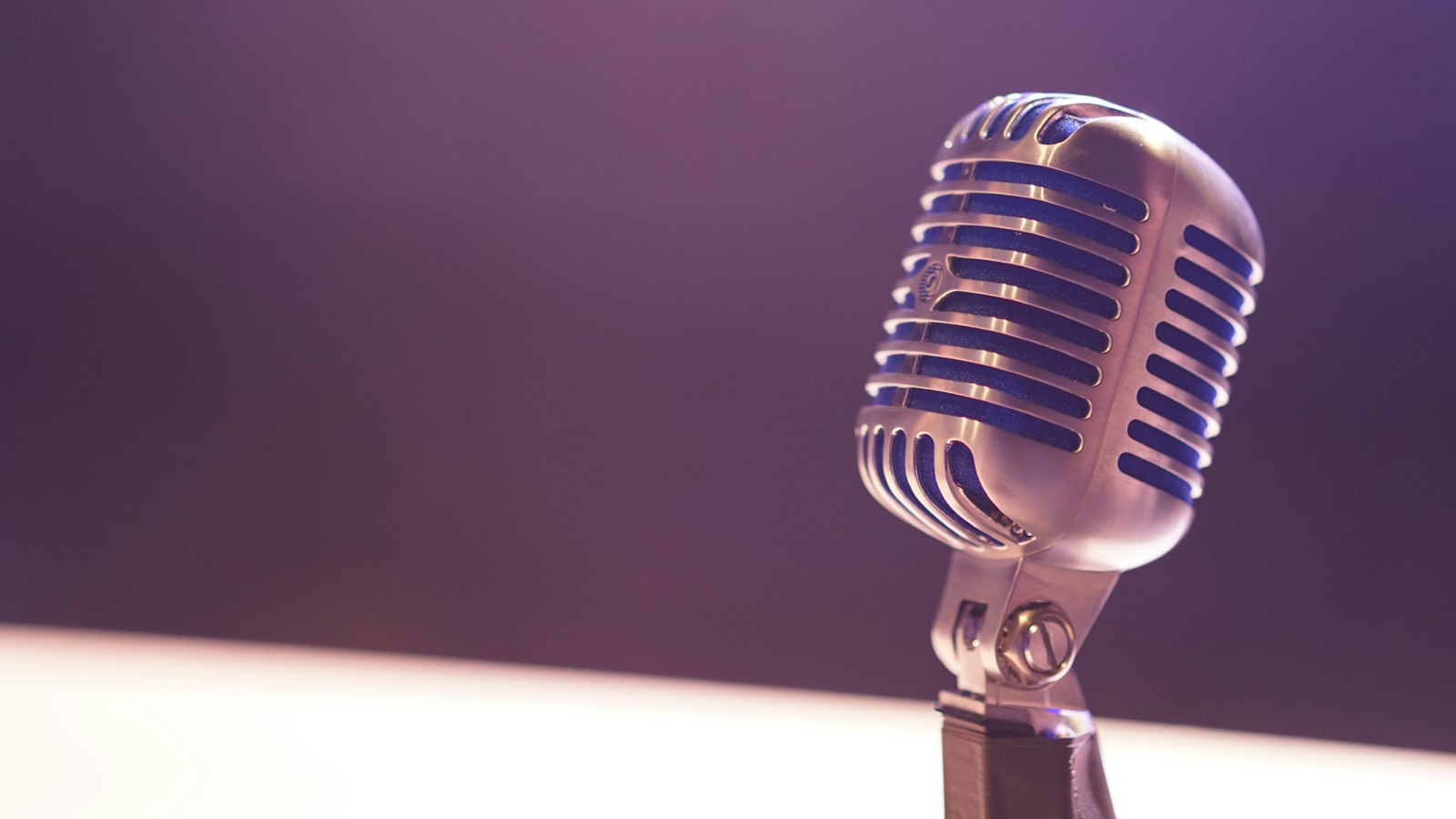 Vintage silver microphone against a soft purple background